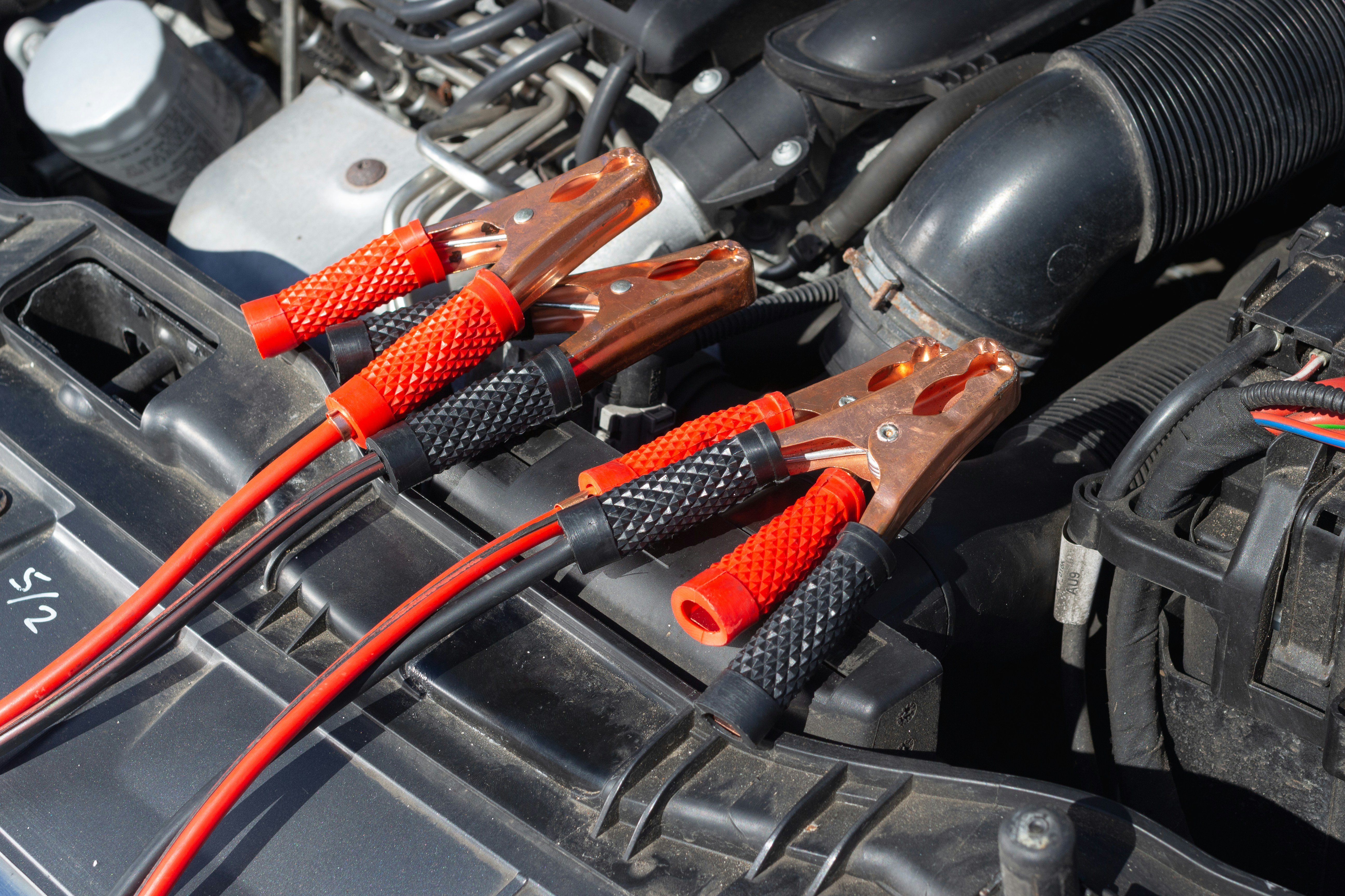 A car battery being started in a garage